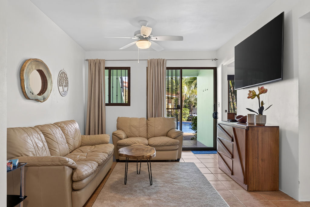 Living room with leather sofas, sliding door open to the pool