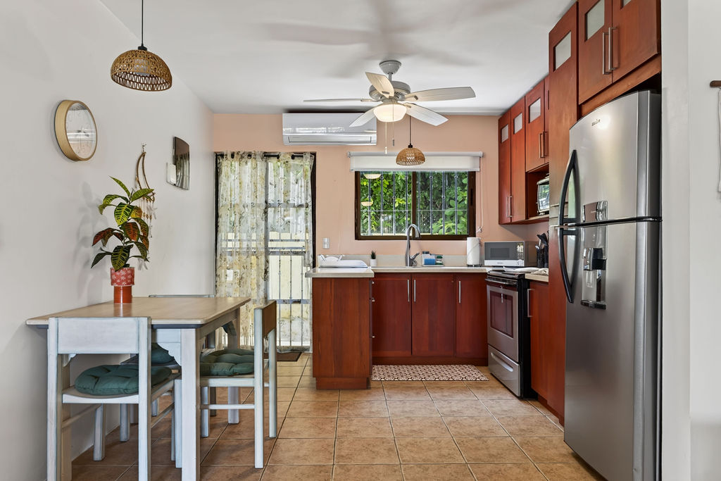 Full kitchen with wood cabinets, gas range, and dining table for four