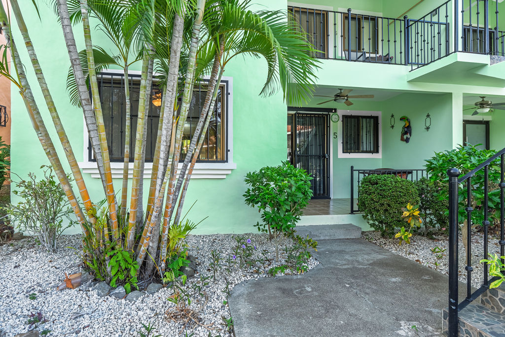 The shared pool and green two story buildings of the Tropical Waves community