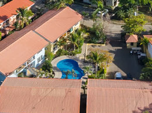 Zoomed aerial crop: the community pool and the mint green building holding unit 5
